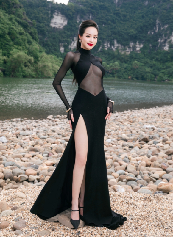 Thanh Thủy lựa chọn thiết kế đầm đen huyền bí với phom dáng bodycon ôm sát, kết hợp vải thun cao cấp và lớp lưới xuyên thấu tinh tế ở phần ngực và bụng, tôn trọn đường cong cơ thể. Điểm nhấn nằm ở đường xẻ đùi cao cùng phần cổ cao sắc sảo, giúp nàng hậu ghi dấu ấn với vẻ đẹp hiện đại, cá tính và đậm chất high fashion. Ảnh: FBNV