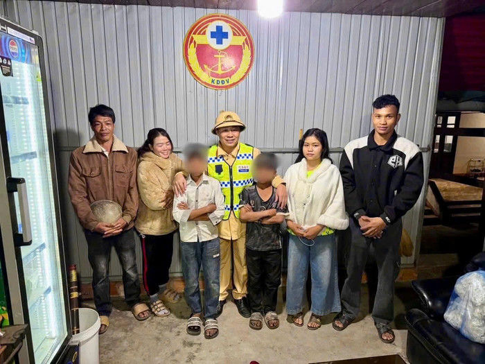 Lực lượng Cảnh sát giao thông đưa 2 cháu về với gia đình an toàn. Ảnh: Bộ Công an