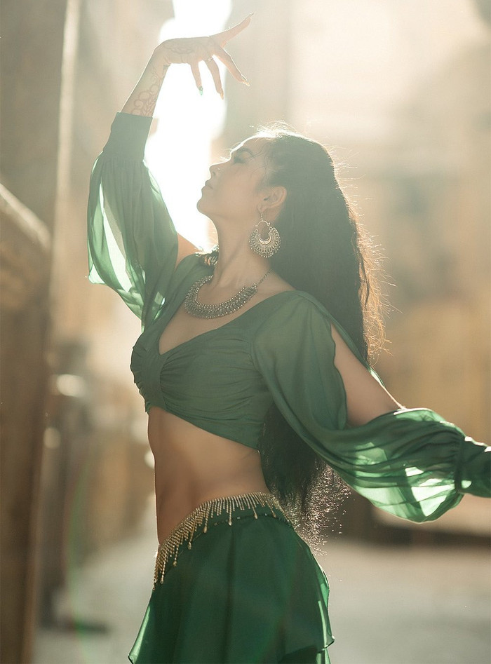 Đặc biệt, nữ ca sĩ rất thành công khi đưa các yếu tố văn hóa Ấn Độ vào tủ đồ một cách tinh tế và tôn vinh. Bộ trang phục xanh lá lấy cảm hứng Ấn Độ với choli crop top bó sát, lehenga xếp ly và hệ thống trang sức bạc cổ điển đã phô diễn vóc dáng săn chắc sau sinh của cô. Cùng với đó, những hình ảnh Võ Hạ Trâm trong tư thế múa truyền thống trên nền kiến trúc cổ không chỉ làm bật lên đường nét cơ thể mà còn thể hiện sự trân trọng với một nền văn hóa giàu bản sắc. Ảnh: FBNV
