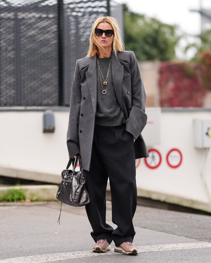 Hãy chọn một chiếc blazer dáng rộng màu xám than, phối cùng quần tây xếp ly đen ống rộng. Thay vì bốt hay giày bệt, giày thể thao thời thượng sẽ mang lại sự thoải mái, đồng thời giúp tổng thể thêm phần cá tính. Ảnh: Harpers Bazaar