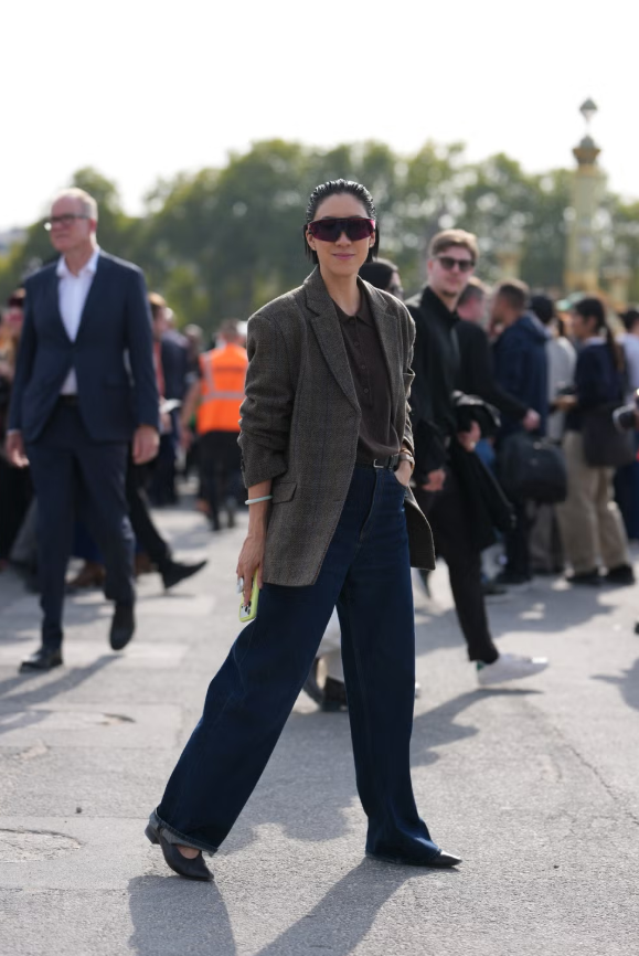 Blazer họa tiết kẻ ô phối cùng quần jeans ống đứng và áo len polo tối giản tạo nên vẻ thanh lịch vượt thời gian, được hoàn thiện bằng giày đế thấp gót nhẹ và thắt lưng tinh giản. Ảnh: Harpers Bazaar