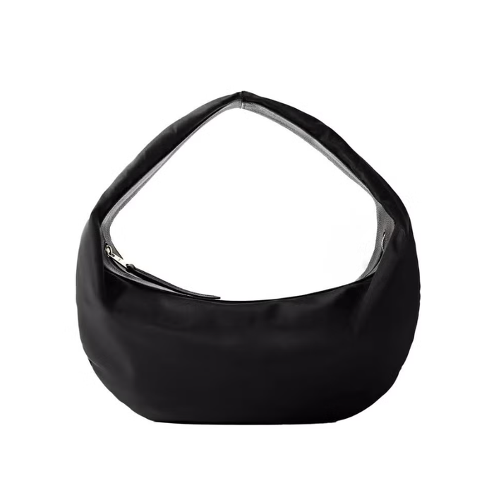 Đối với những ai yêu thích những kiểu dáng độc đáo, chiếc túi Olivia hình tròn của Khaite chắc chắn sẽ là lựa chọn đáng chú ý. Thiết kế mềm mại, dễ chịu với khóa kéo giúp giữ mọi thứ ngăn nắp, được làm từ chất liệu nylon bền chắc và viền bằng da có vân. Ảnh: Harpers Bazaar