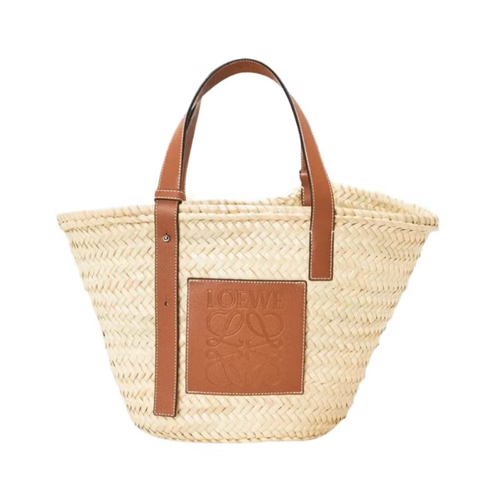 Chiếc túi đan bằng sợi raffia của Loewe được yêu thích nhờ miếng da có logo Anagram của thương hiệu, cùng với dây đeo vai có thể điều chỉnh để dễ dàng sử dụng hàng ngày. Ảnh: Harpers Bazaar