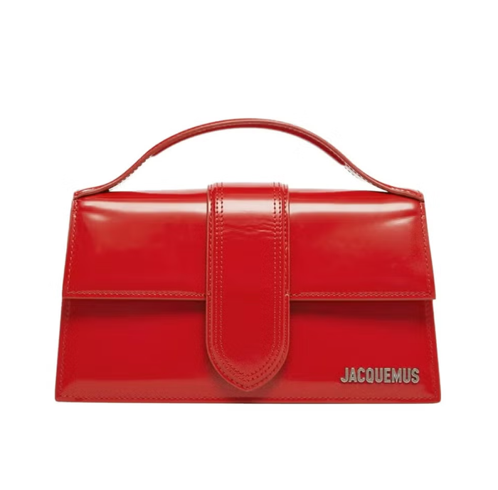 Nếu bạn không muốn đầu tư vào một chiếc túi tote hoặc satchel cỡ lớn, thì một chiếc túi có kiểu dáng cứng cáp như Le Grand Bambino của Jacquemus là một lựa chọn tuyệt vời. Chiếc túi xách tay màu đỏ anh đào này được làm từ da bóng mịn và được hoàn thiện với logo chữ bằng kim loại màu bạc. Bạn có thể xách tay hoặc sử dụng dây đeo vai khi muốn rảnh tay. Ảnh: Harpers Bazaar