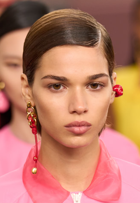 Tại Fendi, ngôi rẽ lệch tôn lên kiểu búi thấp suôn mượt, nổi bật giữa sàn diễn khi kết hợp cùng lớp trang điểm gần như tối giản và bảng màu rực rỡ của bộ sưu tập. Tinh thần slick & sleek cũng xuất hiện tại Khaite và Grace Ling, khẳng định xu hướng tóc gọn gàng, hiện đại. Ảnh: Launchmetrics Spotlight&nbsp;