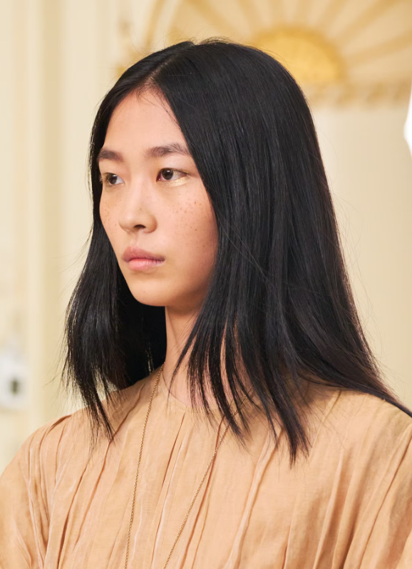 Tại show của Ulla Johnson, lớp mascara đen truyền thống được thay thế bằng phiên bản mascara vàng biến tấu. Chuyên gia trang điểm Romy Soleimani đã kết hợp phấn mắt ánh vàng mịn như bơ của Sisley cùng dung dịch pha trộn chuyên dụng, sau đó dùng cọ quạt phủ lớp chất lỏng ánh kim lên hàng mi, tạo hiệu ứng lấp lánh đầy ấn tượng. Ảnh: Launchmetrics Spotlight&nbsp;