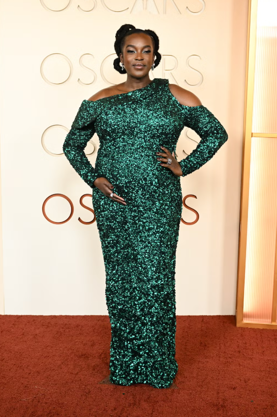 Wunmi Mosaku lựa chọn thiết kế của Louis Vuitton với váy xanh ngọc ánh kim ôm dáng, lệch vai cut-out và tay dài. Chất liệu sequin phủ toàn bộ giúp tổng thể nổi bật, toát lên vẻ sang trọng và quyền lực. Ảnh: Harpers Bazaar