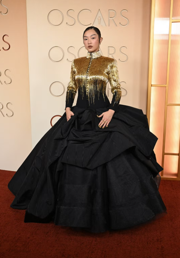 Audrey Nuna xuất hiện nổi bật với váy dạ hội cổ cao tay dài tông đen - vàng ánh kim, phần thân trên đính sequin tạo hiệu ứng ombré lấp lánh, kết hợp chân váy phồng lớn ấn tượng. Cô hoàn thiện diện mạo bằng trang sức đặt làm riêng của Thom Browne và Chopard. Ảnh: Harpers Bazaar