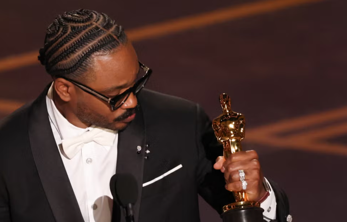 Ryan Coogler diện kiểu tóc tết lấy cảm hứng từ phim Sinners khi nhận giải Oscar. Ảnh: Getty Images