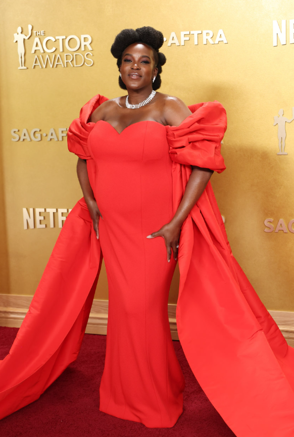 Wunmi Mosaku nổi bật trong thiết kế dạ hội đỏ rực ôm sát, gây ấn tượng với phần tay bồng ngoại cỡ. Cô hoàn thiện tổng thể bằng trang sức đặt riêng từ Louis Vuitton và Messika. Ảnh: Getty Images