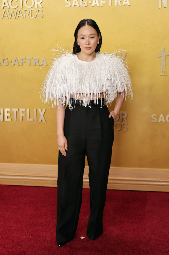 Yerin Ha xuất hiện trong thiết kế của Balenciaga với áo lông vũ trắng phủ kín vai và ngực, tạo hiệu ứng bồng bềnh. Cô phối cùng quần âu đen ống suông cạp cao, mang tinh thần menswear hiện đại. Ảnh: Getty Images