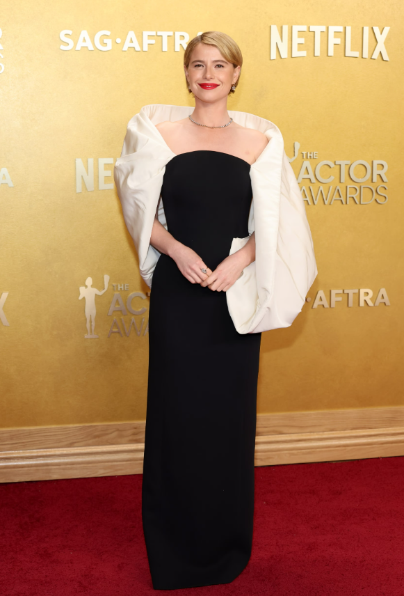 Jessie Buckley lựa chọn đầm đen tối giản, tạo điểm nhấn bằng cấu trúc tay áo trắng phồng ngoại cỡ ôm trọn phần vai. Cô hoàn thiện diện mạo với trang sức từ Balenciaga và Jessica McCormack. Ảnh: Getty Images