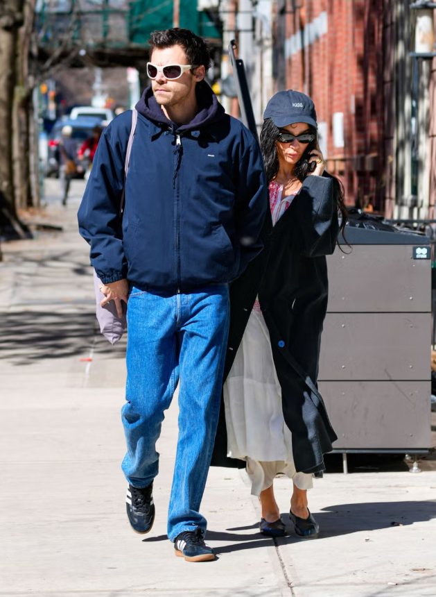 Zoë Kravitz chứng minh rằng những set đồ mùa xuân ấn tượng thường xuất phát từ sự kết hợp bất ngờ. Trong một lần xuất hiện cùng Harry Styles tại New York, cô mix maxi thêu nhẹ nhàng với túi The Row bằng raffia, phối cùng áo khoác đen sắc nét và giày bệt, kết hợp nón logo mang phong cách sporty. Tổng thể là minh chứng cho việc những outfit “It girl” xuất sắc thường đến từ sự đối lập hài hòa giữa các yếu tố tưởng chừng không liên quan. Ảnh: Getty Images