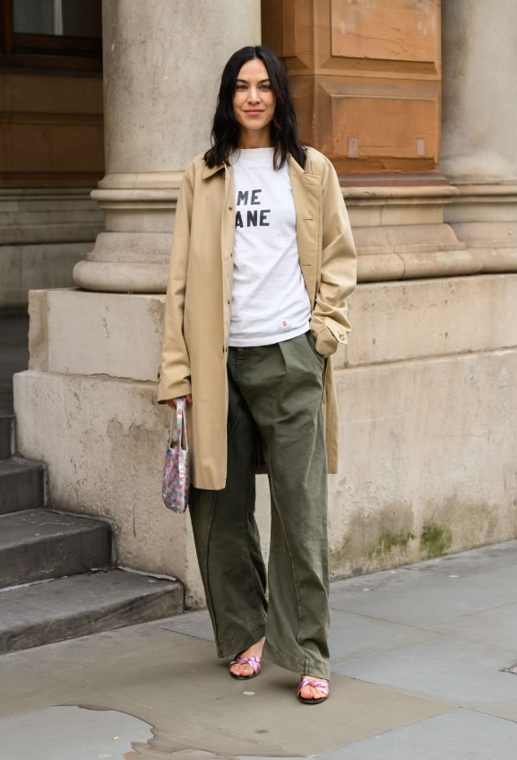 Một chiếc trench khaki kết hợp với các món đồ basic tinh tế là combo an toàn, nhưng để tạo nét phá cách, hãy thử áo thun graphic + quần utility tone khác với đen. Giày metallic hồng Barbie và túi sequin cùng tone sẽ mang đến điểm nhấn tinh tế, khiến tổng thể nổi bật mà không quá phô trương. Ảnh: Getty Images
