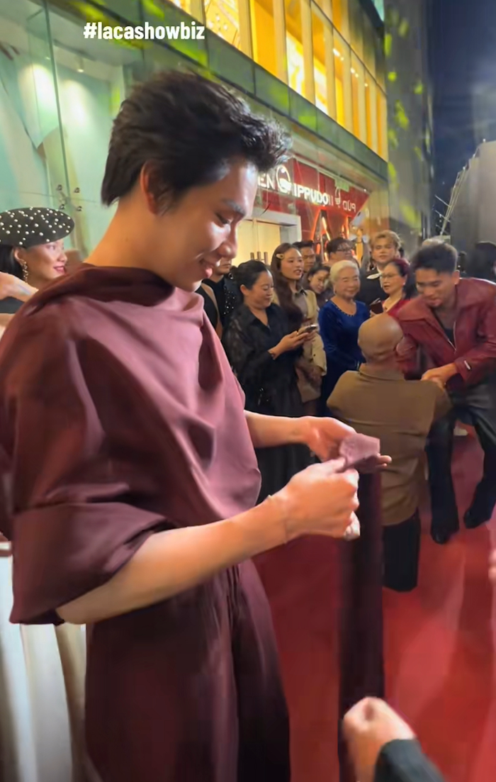 Quang Trung hoang mang khi tà áo bị rơi trong lúc đang có mặt ở thảm đỏ sự kiện công chiếu phim của Mỹ Tâm. Ảnh: lacshowbiz