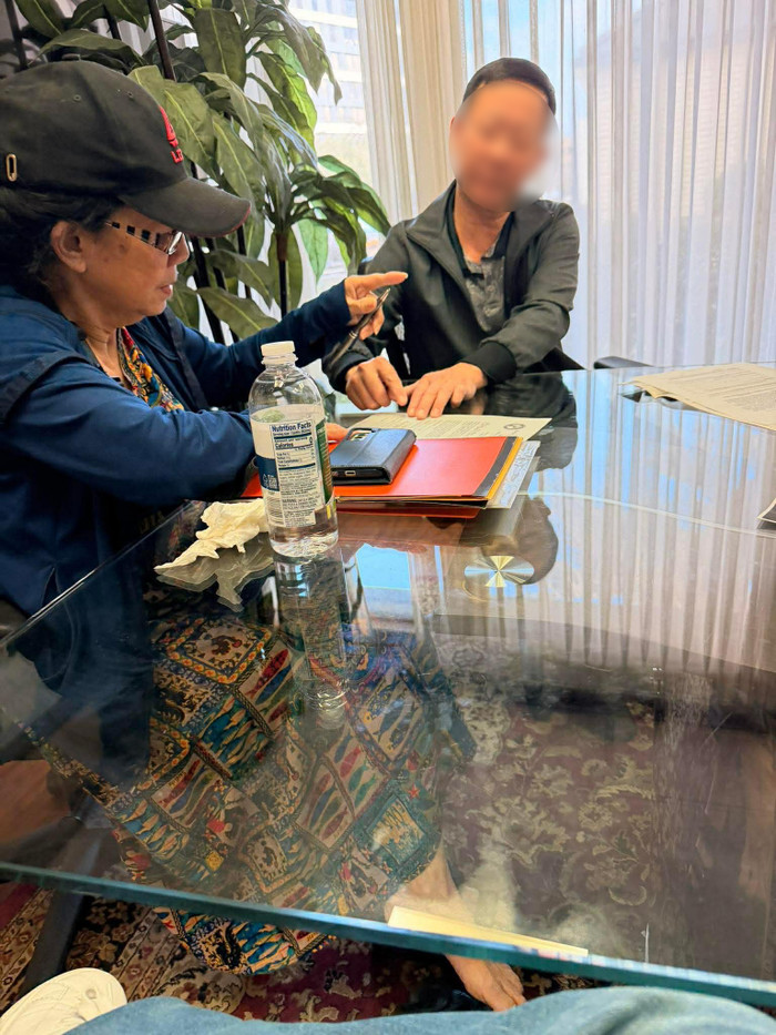 Mẹ Kasim Hoàng Vũ làm thủ tục nhận thi hài của con trai. (Ảnh Quí Ngọc)