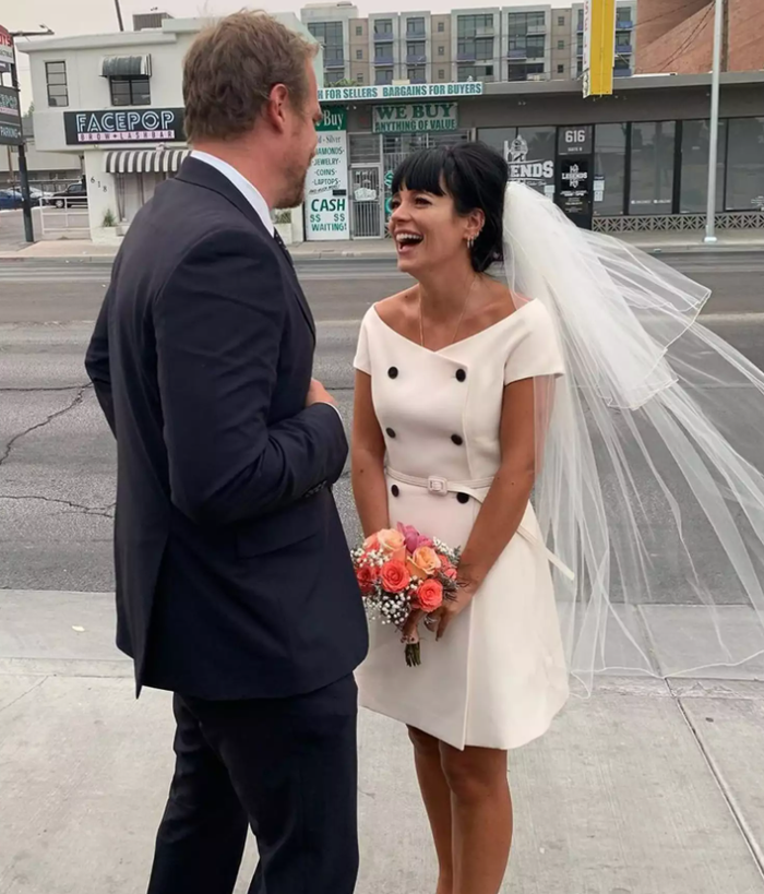 Lily Allen mang đậm tinh thần thập niên 60 khi diện chiếc váy mini trễ vai dáng double-breasted của Dior, kết hợp khăn voan ngắn trong lễ cưới tại nhà nguyện Las Vegas năm 2020 với David Harbour. Ảnh: Lily Allen