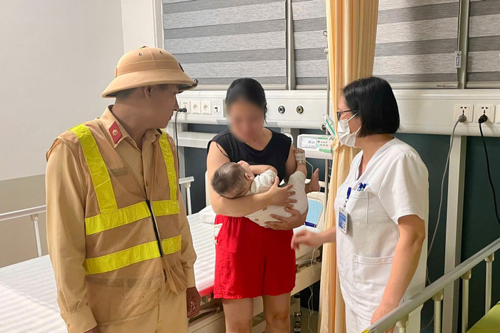 Lực lượng CSGT đã nhanh chóng hỗ trợ người mẹ đưa em bé đến bệnh viện. Ảnh: Công an TP Hà Nội
