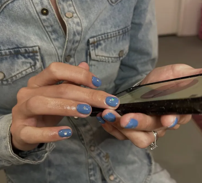 Nhóm tối giản lại ưa chuộng nail ngắn màu xanh đơn sắc, điểm thêm sticker ngôi sao hologram để tạo nét vui mắt mà không phá vỡ sự gọn gàng.