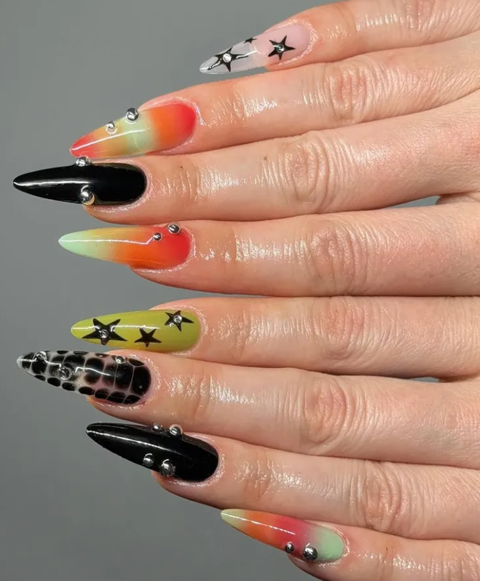 Zendaya trong vai Rue đại diện cho phong cách phá cách hơn với nail đen điểm sao, đá và neon, có thể chọn dáng almond hoặc móng ngắn.