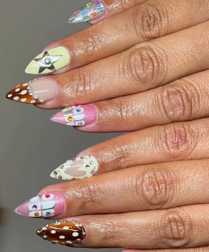 Một thiết kế tiêu biểu kết hợp sequin cầu vồng, nhũ hồng, hoa 3D, họa tiết đốm fawn cùng chi tiết kim loại mang hơi hướng “girly grill”, tạo nên tổng thể nổi bật, giàu tính trang trí nhưng vẫn hài hòa.