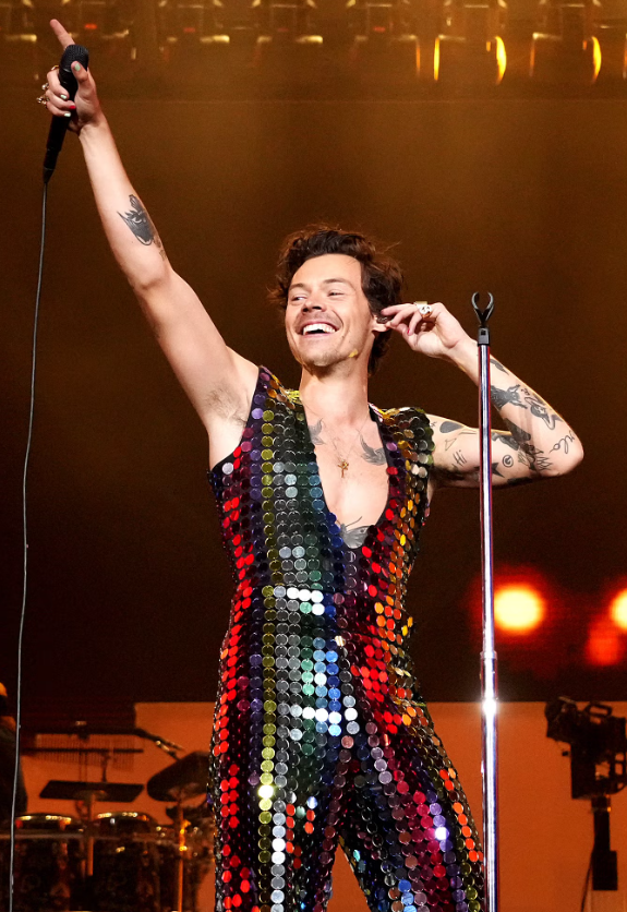Harry Styles gây ấn tượng mạnh khi xuất hiện trong bộ jumpsuit đính sequin lấp lánh trong lần đầu làm headliner. Thiết kế táo bạo, giàu tính trình diễn nhanh chóng trở thành một trong những khoảnh khắc thời trang biểu tượng của lễ hội.