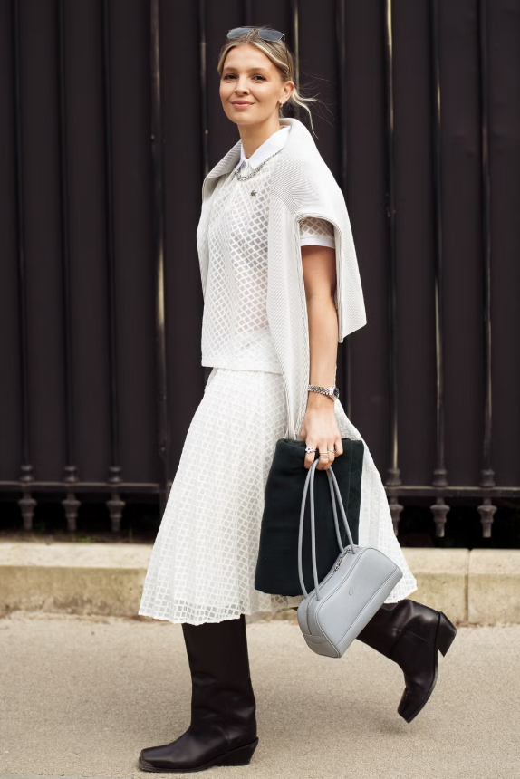 Áo polo dệt kim lỗ thoáng là lựa chọn tuyệt vời nhờ khả năng thoáng khí trong thời tiết nóng. Kết hợp cùng boots đen cao cổ và váy trắng xoè để tạo nét năng động theo phong cách boho.&nbsp;