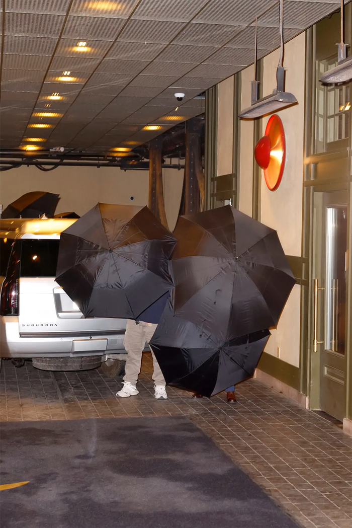 Taylor Swift và Travis Kelce gây chú ý khi xuất hiện kín đáo, che ô lớn để tránh bị nhận diện khi bước vào câu lạc bộ.