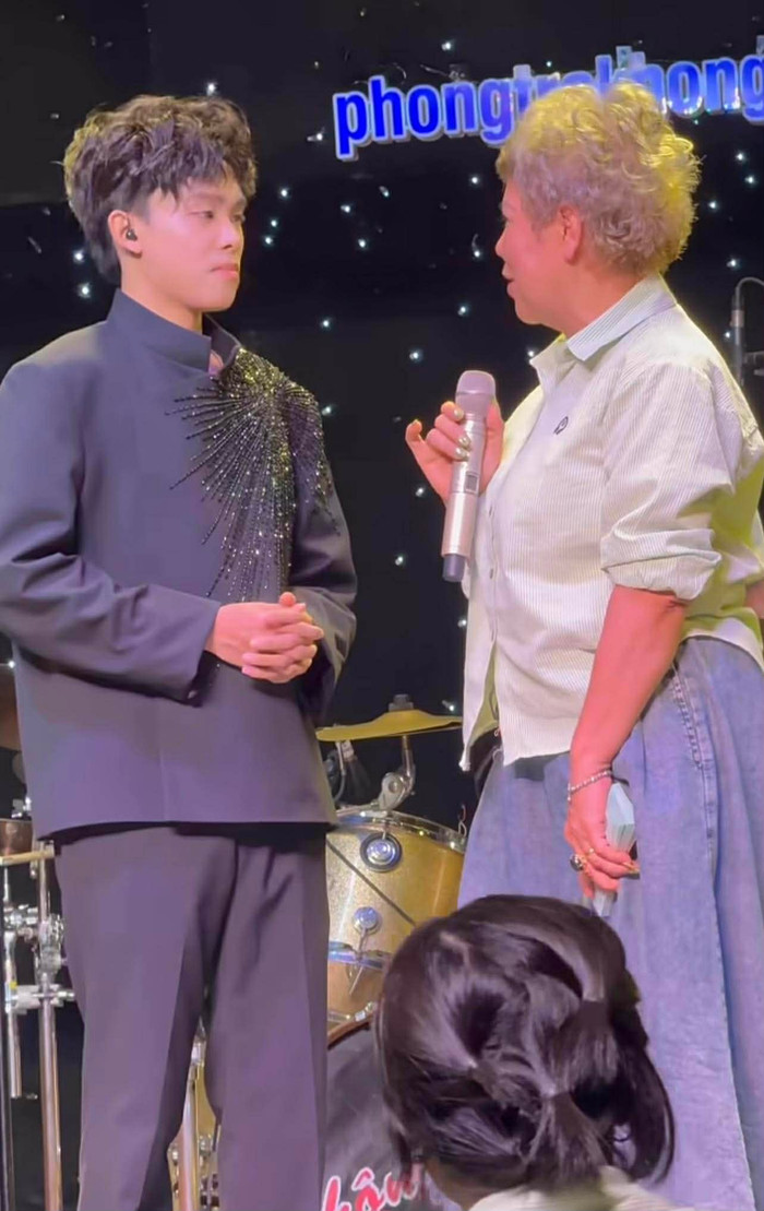 Một khán giả lên sân khấu chia sẻ về Hồ Văn Cường, cũng như gửi tặng nam ca sĩ món quà đặc biệt. (Ảnh chụp màn hình từ FB Nguyên Nè)