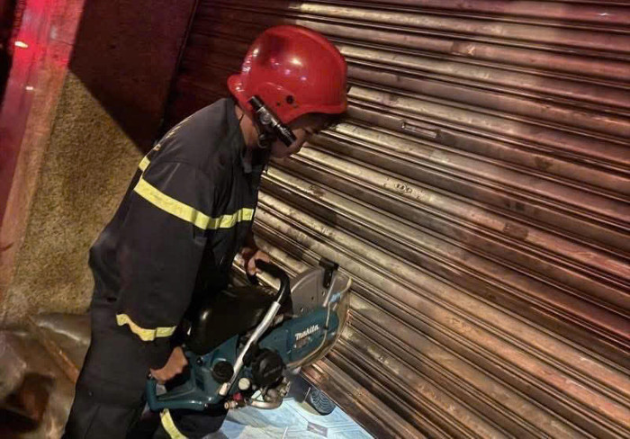 Lực lượng chức năng cắt cửa cuốn tiếp cận hiện trường.&nbsp;