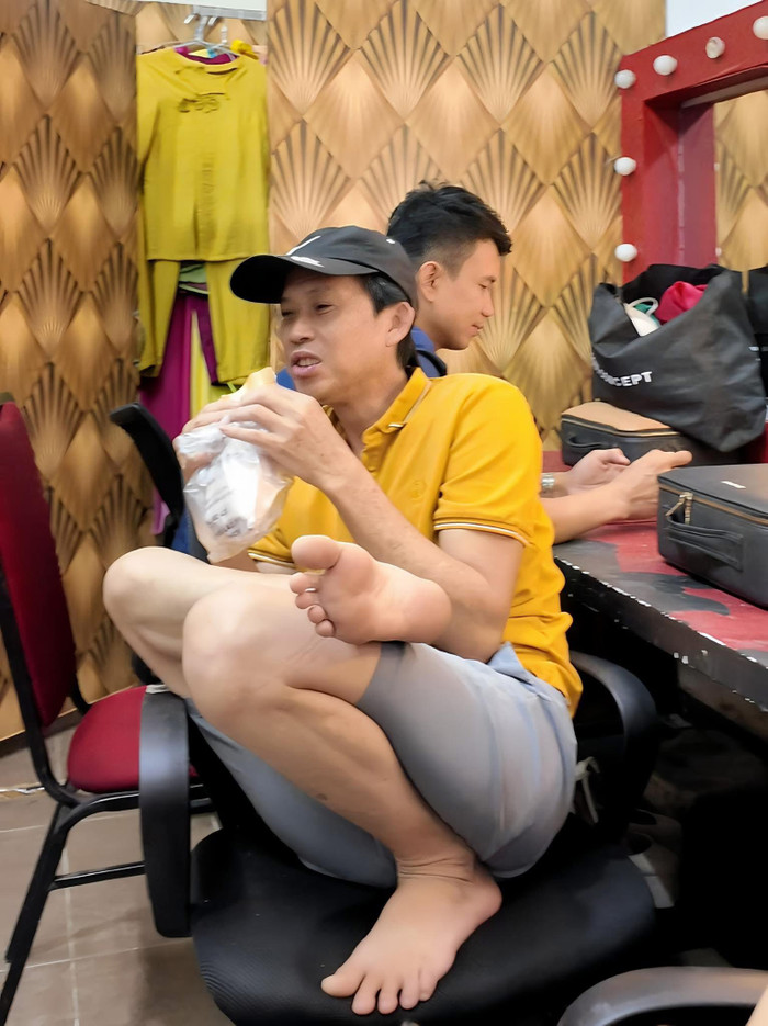 Nghệ sĩ Hoài Linh ăn bánh mì ngon lành ở hậu trường.