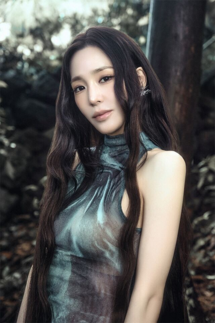 Tiffany Young đứng giữa thiên nhiên xanh mướt.