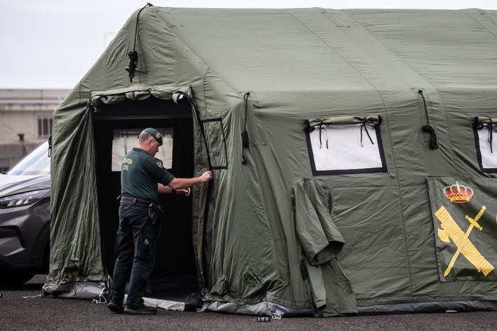 Một thành viên của Lực lượng Cảnh sát Quốc gia (Guardia Civil) hoàn tất việc dựng lều tại điểm đón dự kiến ​​dành cho hành khách từ tàu MV Hondius tại cảng Granadilla. (Getty)