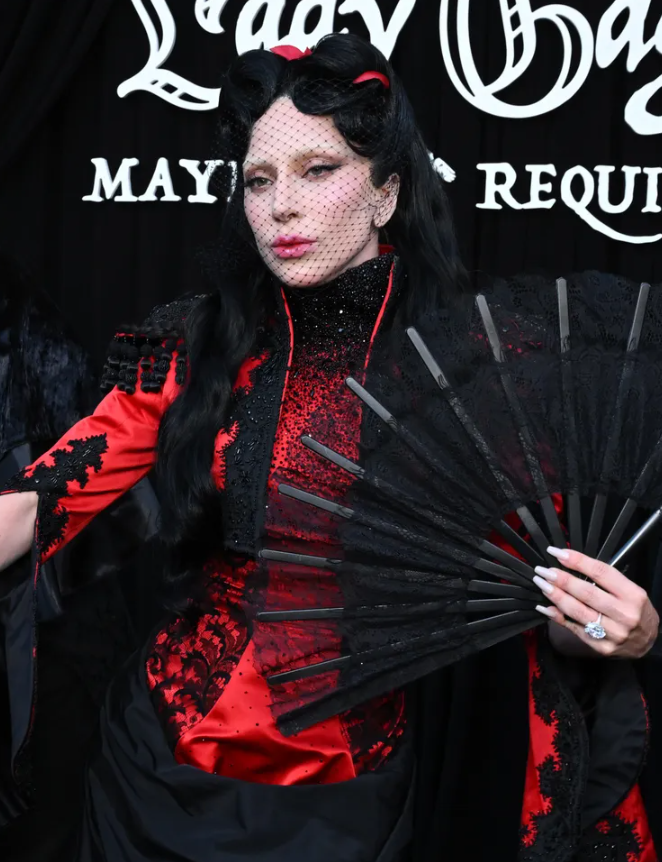 Lady Gaga kết hợp khăn voan lưới đen che mặt, quạt ren cổ điển và chiếc nhẫn đính hôn kim cương oval trị giá khoảng 1 triệu USD. Ảnh: Getty Images