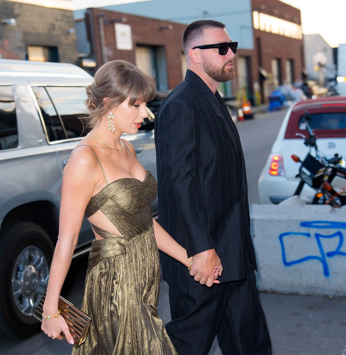 Travis Kelce xuất hiện lịch lãm với bộ suit sọc đen, phối cùng kính râm và giày da.