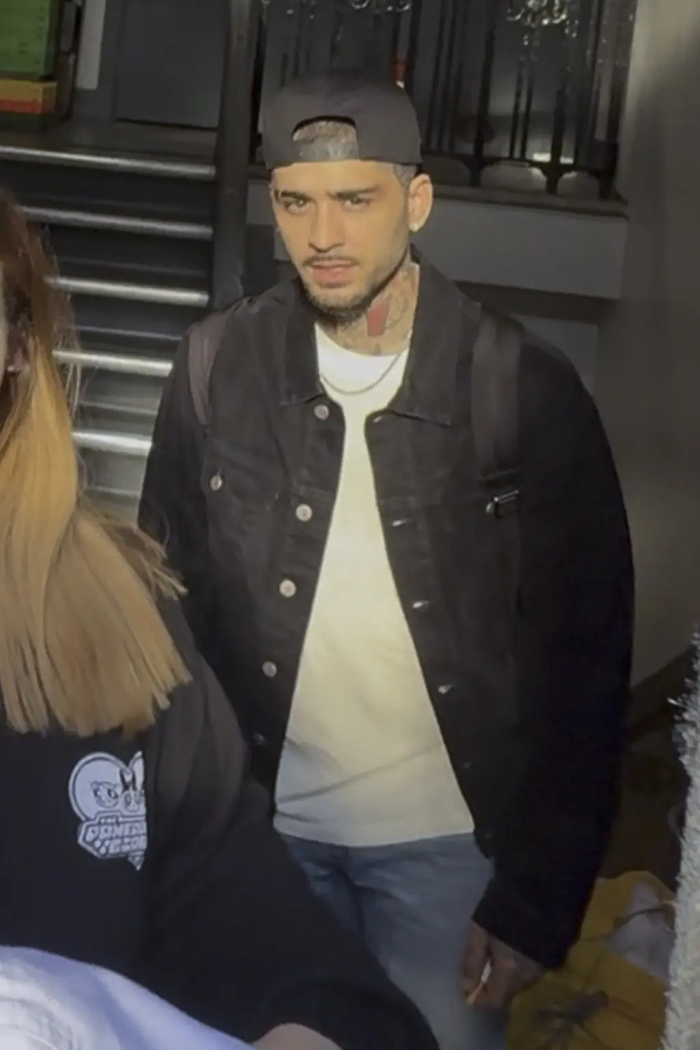 Hình ảnh Zayn Malik bị đám đông vây kín, khó khăn trong việc di chuyển ra xe.