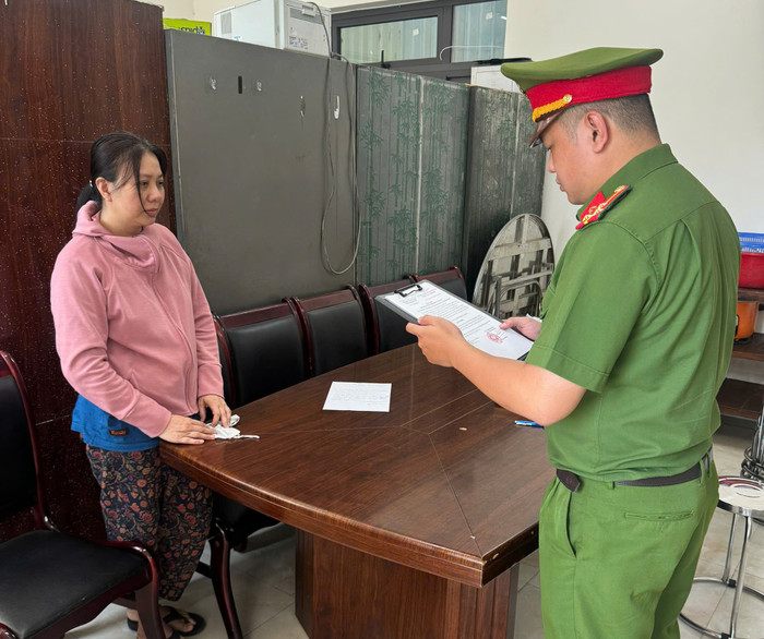 Cơ quan CSĐT Công an TP Đà Nẵng tống đạt các quyết định đối với Đinh Thị Hạnh. Ảnh: Công an TP Đà Nẵng