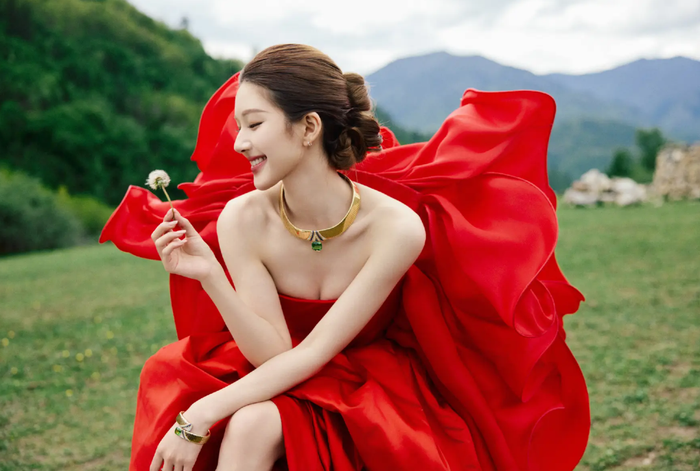 Triệu Lộ Tư hút trọn ống kính với thiết kế đầm đỏ lộng lẫy giữa không gian thảo nguyên xanh mát. Ảnh: Sohu