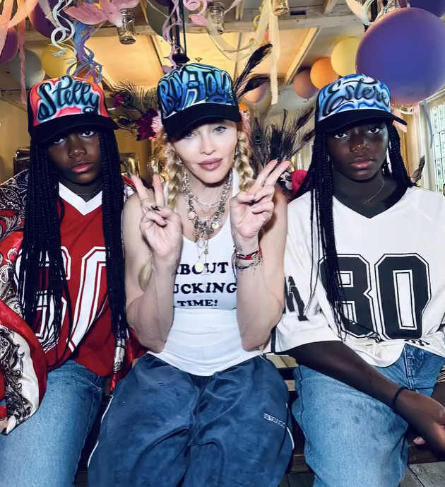 Madonna&nbsp;diện áo tank top gân màu trắng với dòng chữ “About f*ckin time!” được đính đá xanh nổi bật. Ảnh: IGNV