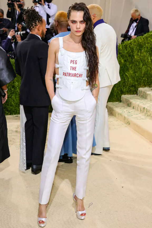 Tại Met Gala 2021, Cara Delevingne gây chú ý khi diện thiết kế của Dior Haute Couture với dòng chữ “Peg the patriarchy”. Thông điệp táo bạo tạo nhiều tranh cãi, khi một số khen ngợi, số khác cho là phản cảm. Luna Matatas lên tiếng nhận là người sáng tạo cụm từ, đồng thời chỉ ra tình trạng ý tưởng của các nghệ sĩ nhỏ thường bị sử dụng mà không được ghi nhận. Ảnh: Getty