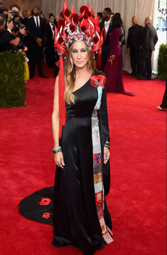 Tại Met Gala 2015 với chủ đề “China: Through the Looking Glass”, Sarah Jessica Parker gây tranh cãi khi diện thiết kế của H&M kết hợp mũ đội đầu của Philip Treacy. Dù một số đánh giá cao sự nổi bật, nhiều ý kiến chỉ trích tạo hình mang tính khuôn mẫu, bị cho là thiếu nhạy cảm với văn hóa châu Á. Ảnh: FilmMagic