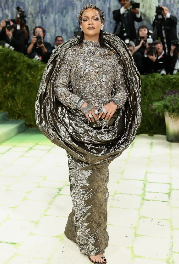 Rihanna có thể là người đến muộn nhất tại Met Gala 2026, nhưng sự chờ đợi đó hoàn toàn xứng đáng. Cô diện một bộ trang phục màu vàng ánh kim của Maison Margiela và điểm thêm phụ kiện là bộ trang sức tóc thiết kế riêng của Jennifer Behr. Ảnh: Getty