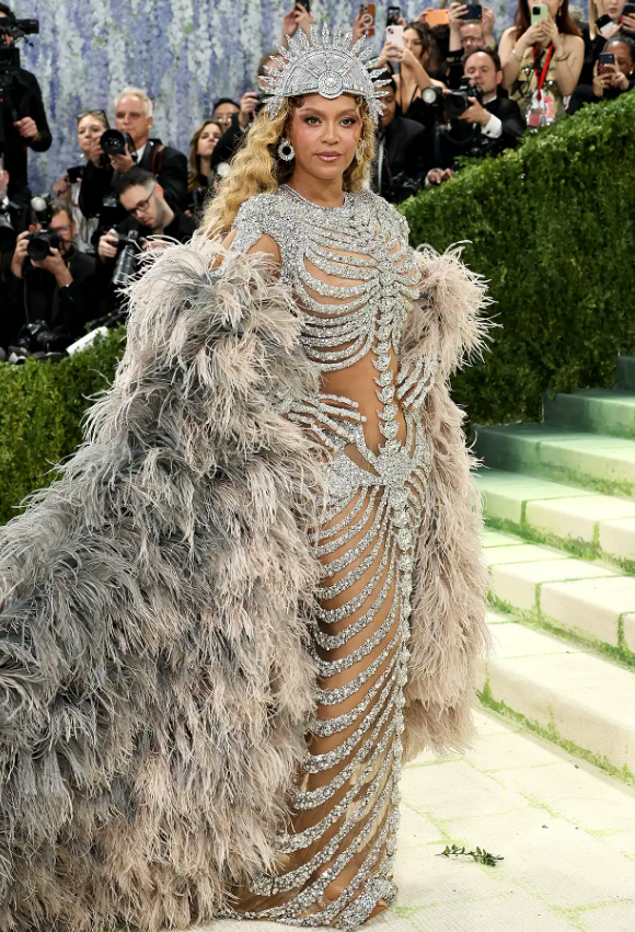 Là một trong những người đồng chủ trì năm nay, Beyoncé đã tạo ấn tượng mạnh mẽ. Cô xuất hiện trong một chiếc váy xuyên thấu đính đầy đá quý, được thiết kế trông giống như một bộ xương, kết hợp với một chiếc áo choàng lông vũ. Ảnh: Getty