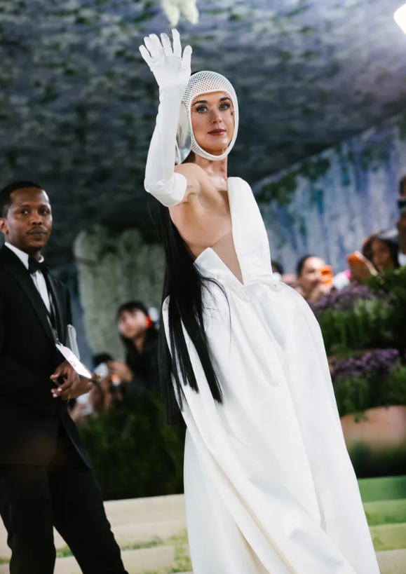 Katy Perry xuất hiện trong thiết kế của Stella McCartney với điểm nhấn là chi tiết ngón tay thứ sáu gắn trên đôi găng tay trắng đồng điệu. Không chỉ gây chú ý bởi hiệu ứng thị giác mang màu sắc ảo giác, thiết kế còn tạo điểm nhấn lạ mắt, góp phần làm nổi bật tinh thần thử nghiệm của thảm đỏ Met Gala năm nay. Ảnh: Getty Images