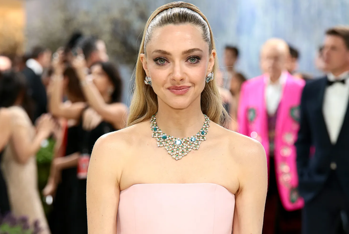 Amanda Seyfried hóa thân như nàng công chúa trong bộ váy Prada màu hồng phấn cùng kiểu tóc búi vương giả đồng điệu. Cô hoàn thiện diện mạo với trang sức Tiffany & Co. gồm khuyên tai kim cương đính aquamarine và vòng cổ nổi bật kết hợp đá xanh zircon, ngọc lục bảo và kim cương. Ảnh: Getty