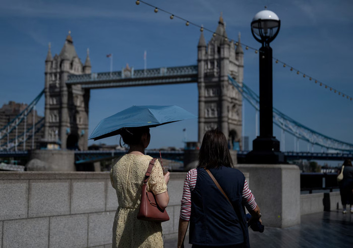 Một người phụ nữ dùng ô che nắng gần Cầu Tháp ở London, Anh, ngày 22 tháng 5 năm 2026. (Ảnh: REUTERS)