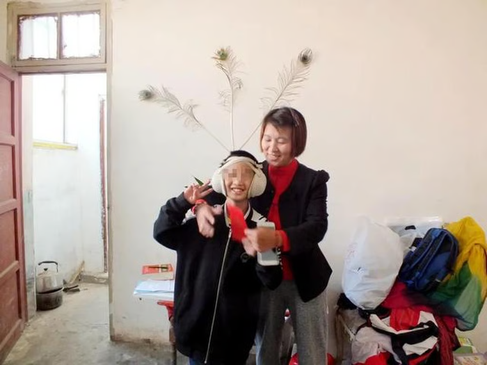 Lele và mẹ nuôi của cậu ấy đang vui vẻ bên nhau khi cậu ấy còn nhỏ. Ảnh: Jimu News.