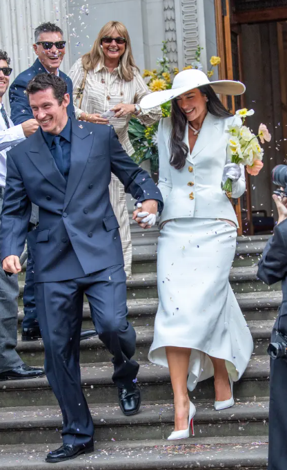Dua Lipa xuất hiện trong một bộ suit cưới phá cách, lấy cảm hứng từ biểu tượng Bianca Jagger, tạo nên hình ảnh vừa hiện đại vừa giàu tính biểu tượng.