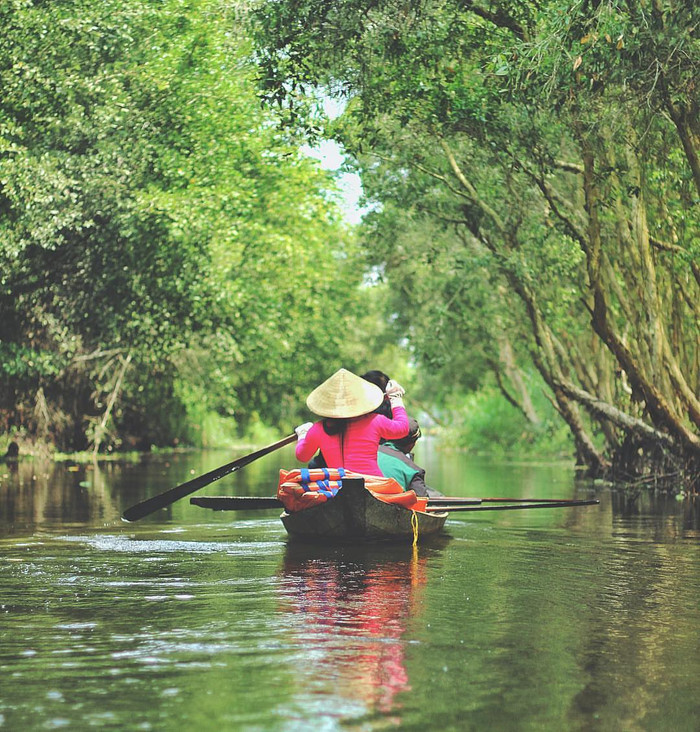 Du khách ngồi thuyền ngắm nhìn cảnh quan sông nước