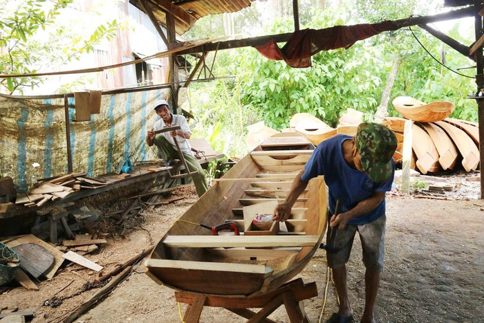 Những người thợ ở làng đóng xuồng gỗ Long Hậu. Ảnh: báo Dân Trí